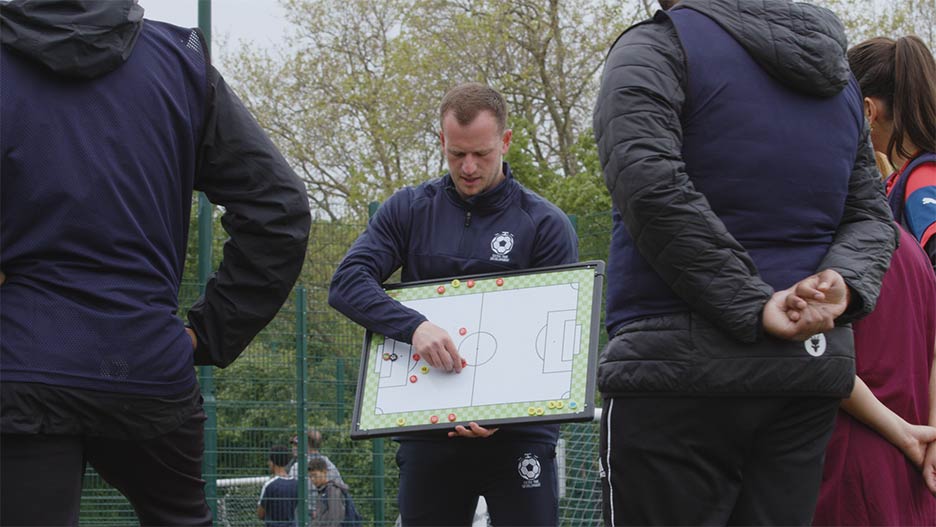 A coach holding up a tactics board